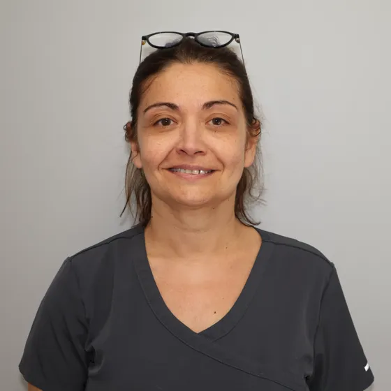 Portrait d’Emmanuelle Fant, souriante, lunettes sur la tête.