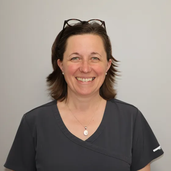 Portrait du Dr Christelle Junot, souriante, en tenue de clinique.